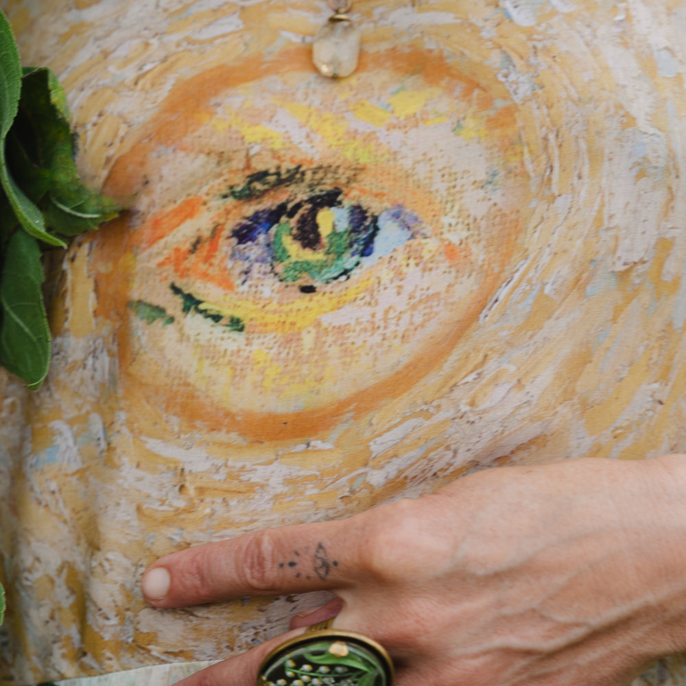 
                  
                    Model wearing bamboo viscose slip dress featuring Van Gogh artwork and quote, with painted blossoms, book, sun, and eye in rich sunny tones of jade and gold - Market of Stars
                  
                