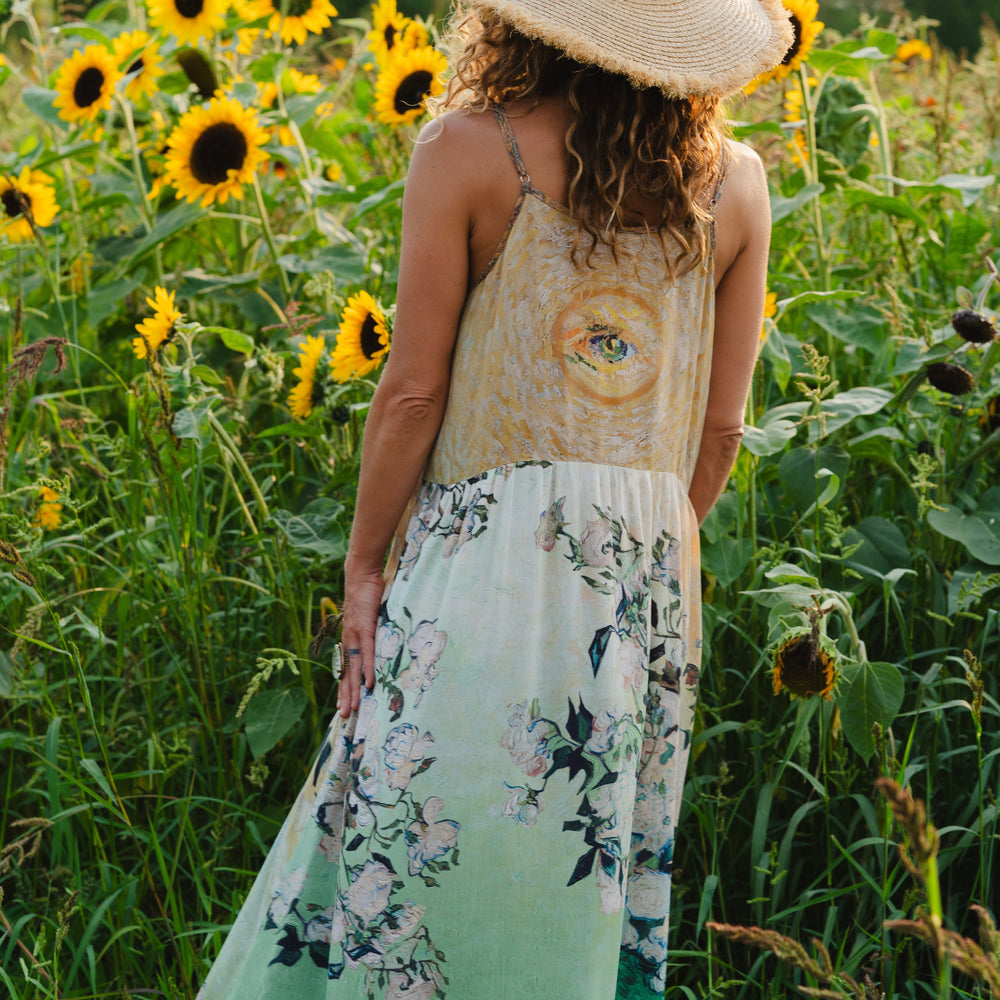 
                  
                    Model wearing bamboo viscose slip dress featuring Van Gogh artwork and quote, with painted blossoms, book, sun, and eye in rich sunny tones of jade and gold - Market of Stars
                  
                