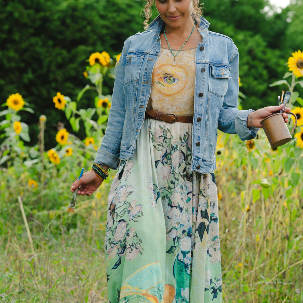 
                  
                    Model wearing bamboo viscose slip dress featuring Van Gogh artwork and quote, with painted blossoms, book, sun, and eye in rich sunny tones of jade and gold - Market of Stars
                  
                
