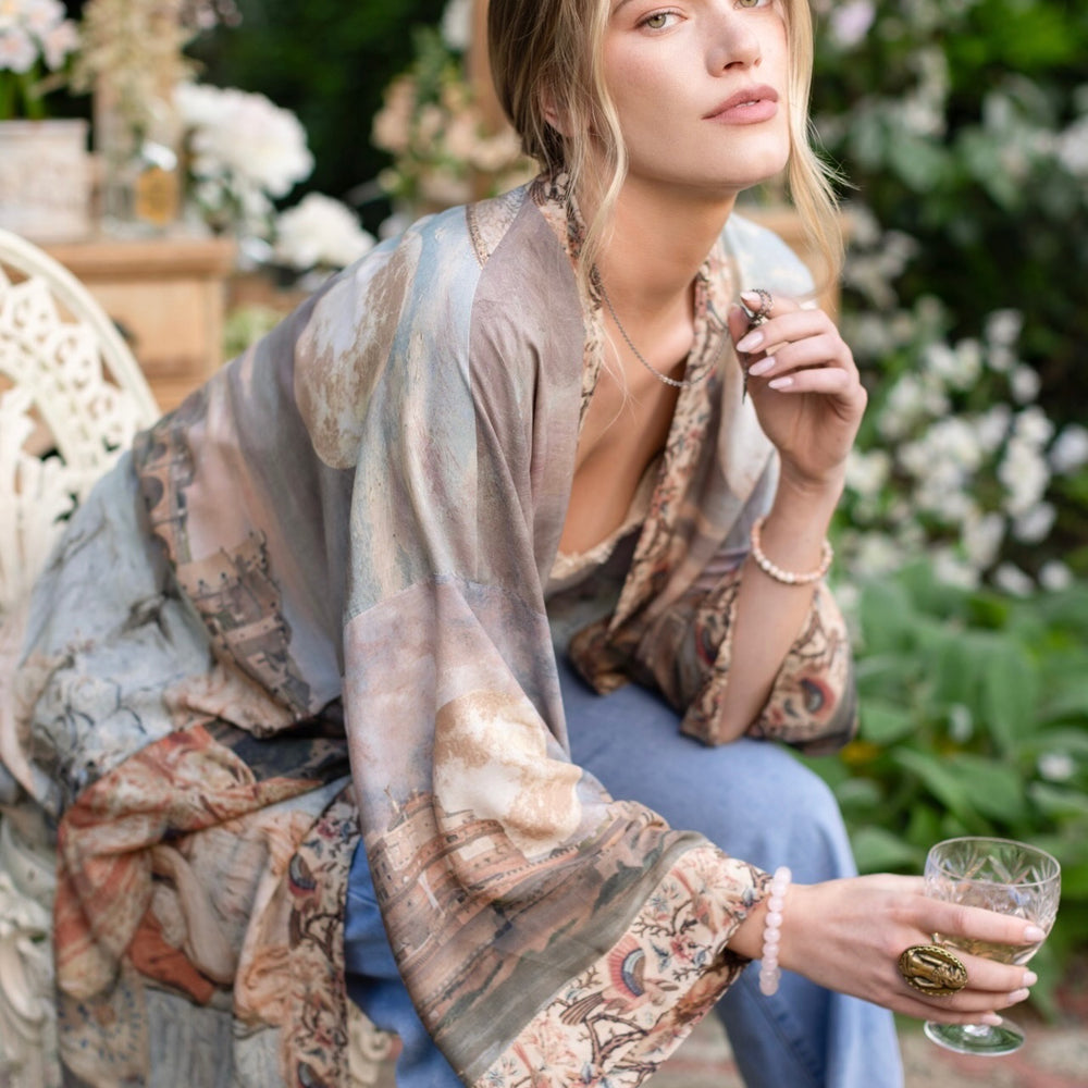 
                  
                    Model wearing the Imaginarium matinee duster featuring a dreamy collage of historic art, candle chandelier, and sleeping muse inspired by Victorian paintings – Market of Stars
                  
                