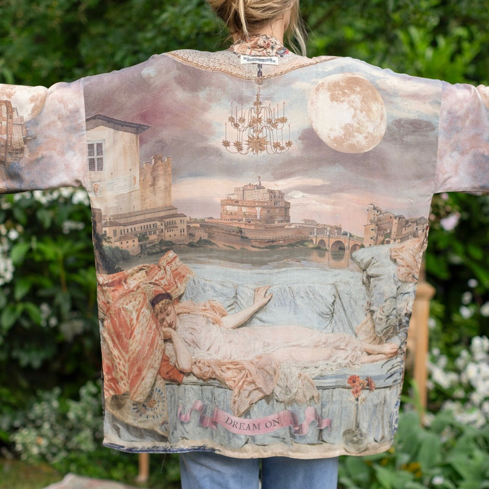 
                  
                    Model wearing the Imaginarium matinee duster featuring a dreamy collage of historic art, candle chandelier, and sleeping muse inspired by Victorian paintings – Market of Stars
                  
                