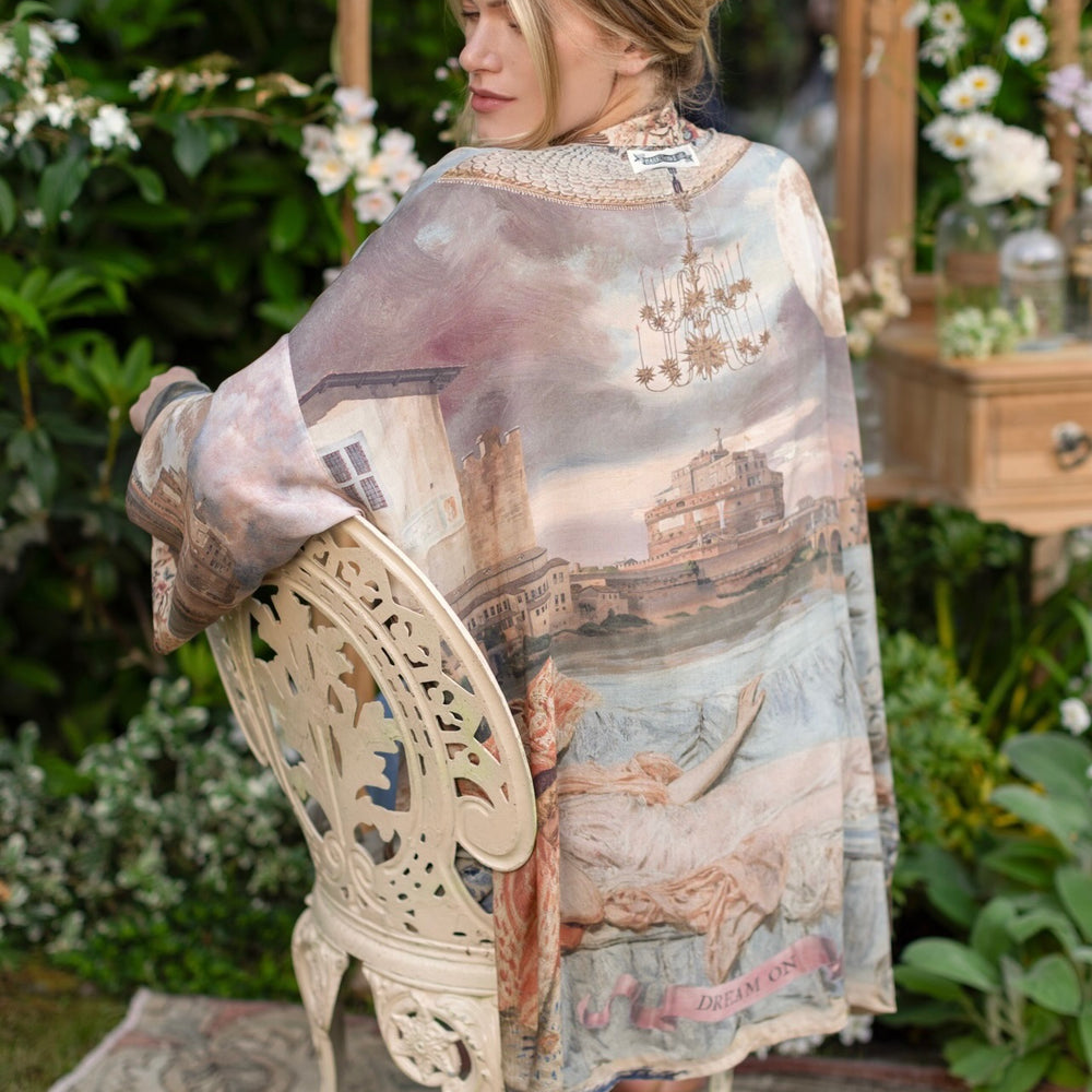 
                  
                    Model wearing the Imaginarium matinee duster featuring a dreamy collage of historic art, candle chandelier, and sleeping muse inspired by Victorian paintings – Market of Stars
                  
                