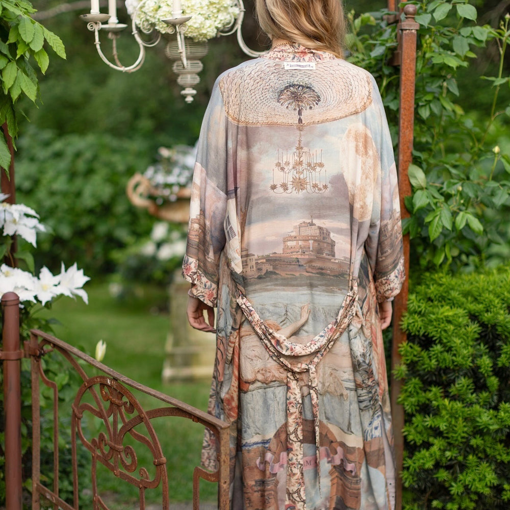 
                  
                    Model standing in airy Imaginarium opera duster featuring layered dreamscape art, candlelit chandelier, and sleeping muse inspired by Victorian paintings – Market of Stars
                  
                