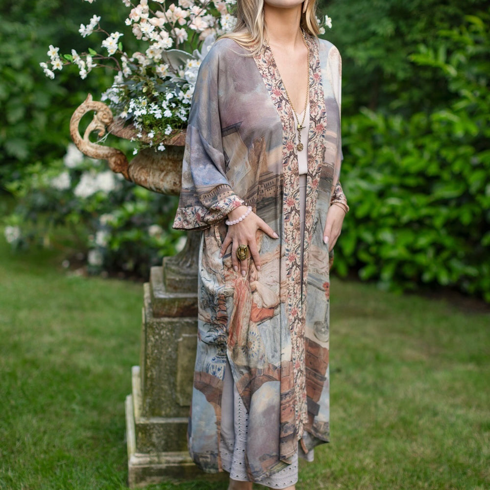 
                  
                    Model standing in airy Imaginarium opera duster featuring layered dreamscape art, candlelit chandelier, and sleeping muse inspired by Victorian paintings – Market of Stars
                  
                