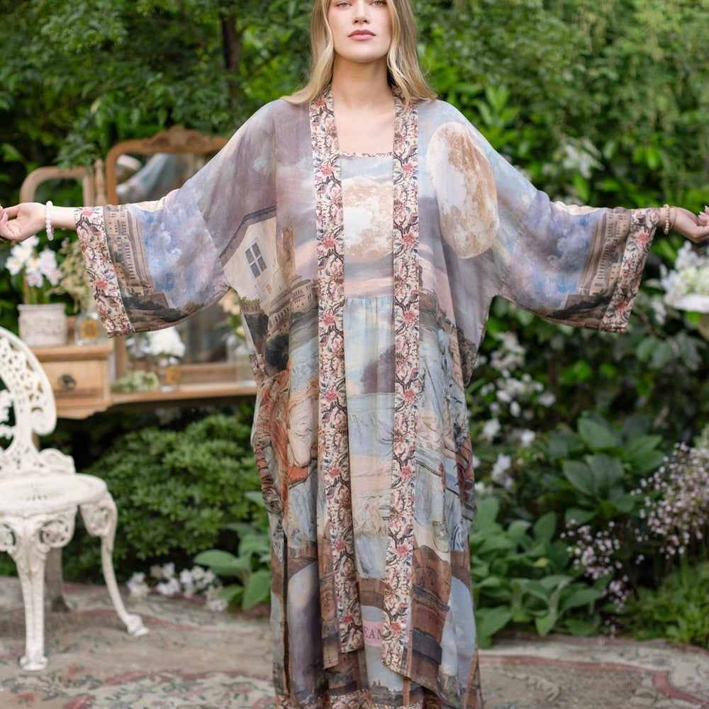 
                  
                    Model standing in airy Imaginarium opera duster featuring layered dreamscape art, candlelit chandelier, and sleeping muse inspired by Victorian paintings – Market of Stars
                  
                