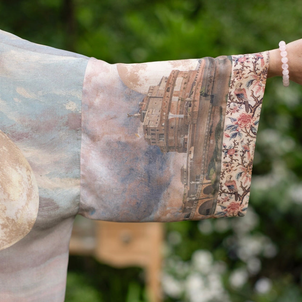 
                  
                    Model standing in airy Imaginarium opera duster featuring layered dreamscape art, candlelit chandelier, and sleeping muse inspired by Victorian paintings – Market of Stars
                  
                