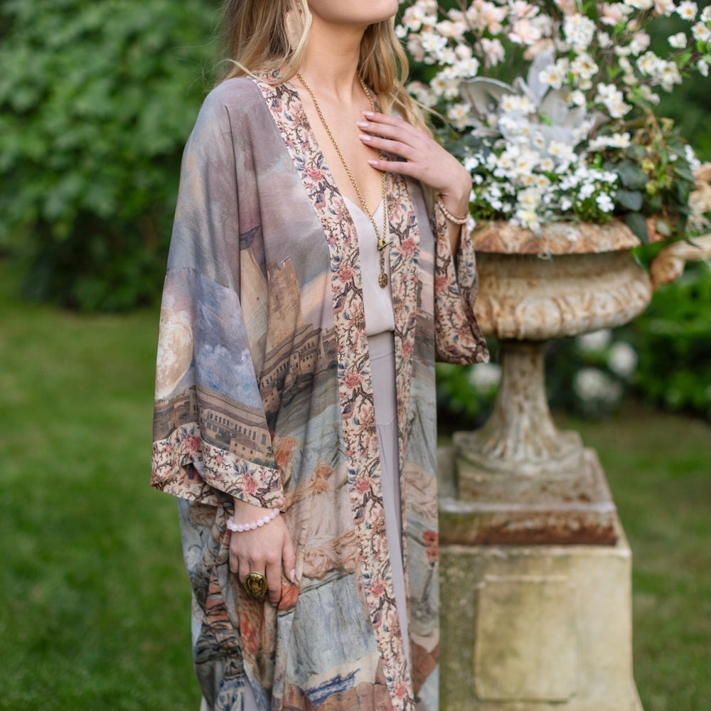 
                  
                    Model standing in airy Imaginarium opera duster featuring layered dreamscape art, candlelit chandelier, and sleeping muse inspired by Victorian paintings – Market of Stars
                  
                
