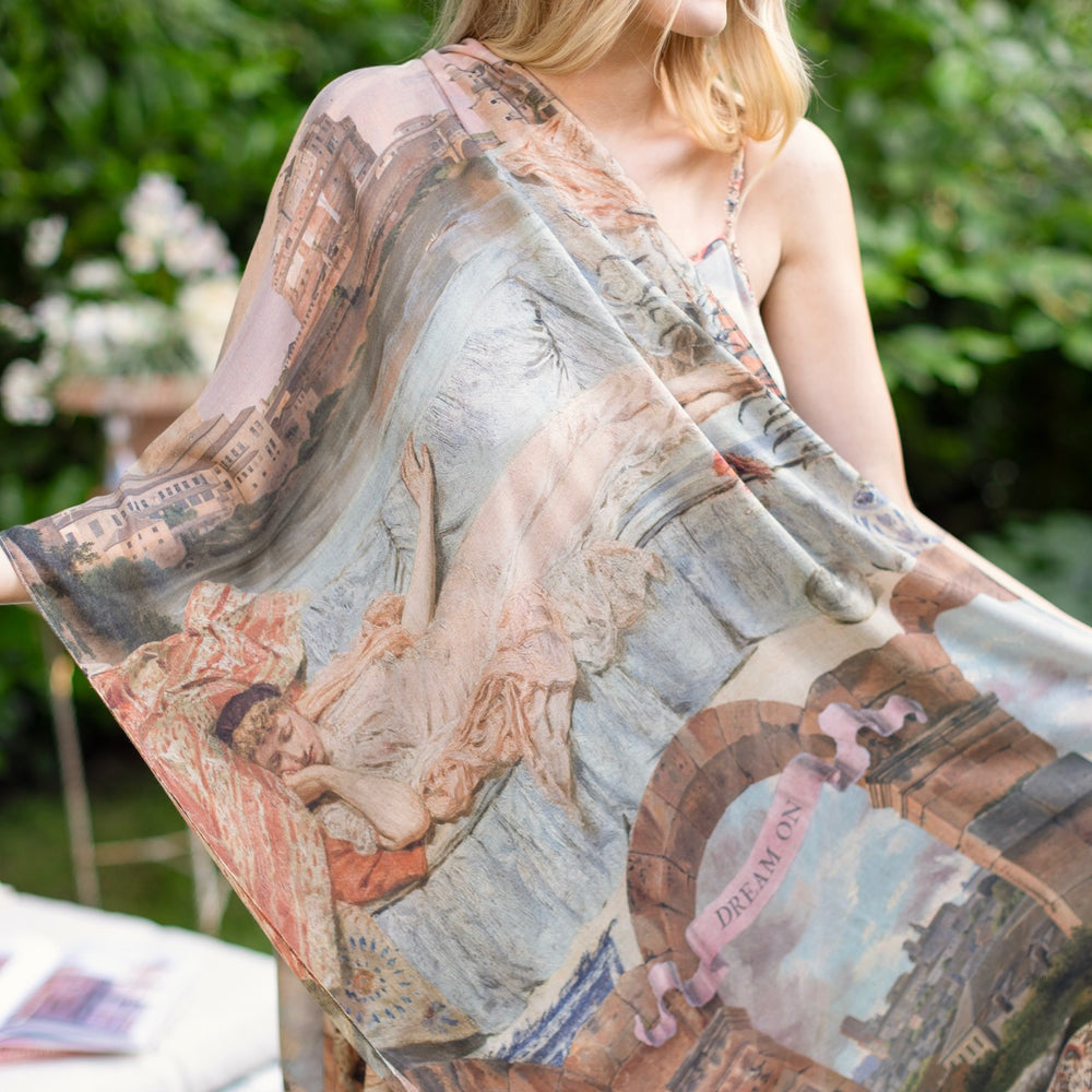 Model wearing airy Imaginarium scarf featuring a romantic collage of dreamy architecture, candlelight, and a sleeping muse – Market of Stars.