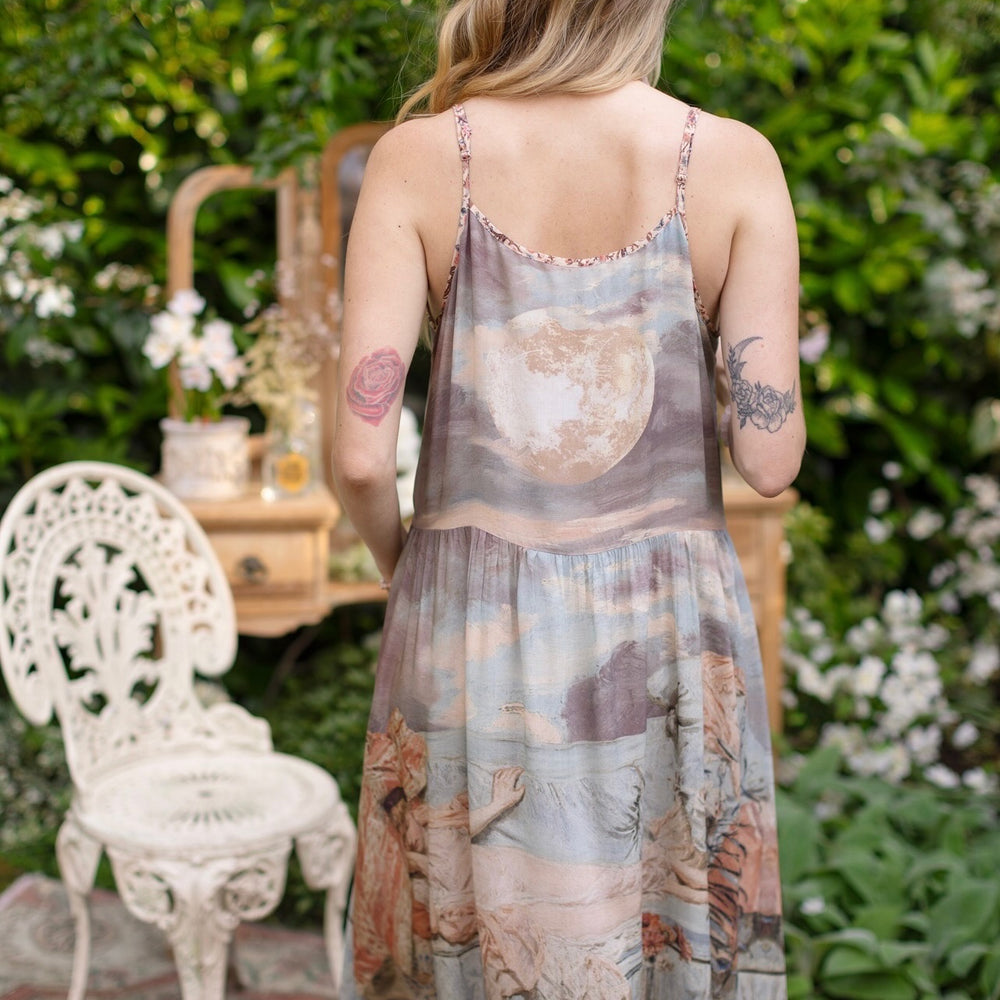 Model wearing the Imaginarium Bohéme Slip Dress featuring a dreamy layered print of historic landscapes, chandeliers, and a sleeping muse – Market of Stars.