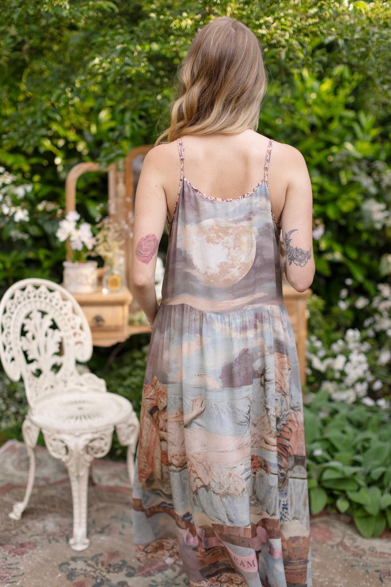 Model wearing the Imaginarium Bohéme Slip Dress featuring a dreamy layered print of historic landscapes, chandeliers, and a sleeping muse – Market of Stars.