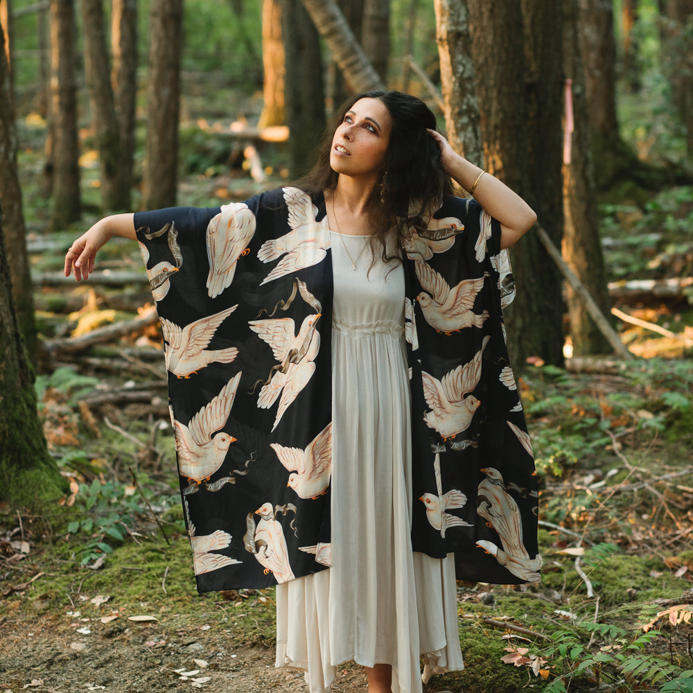 
                  
                    Model wearing the original Market of Stars kimono featuring Victorian-inspired doves and the words “In Stardust We Trust” — a tribute to dreams and possibility – Market of Stars.
                  
                