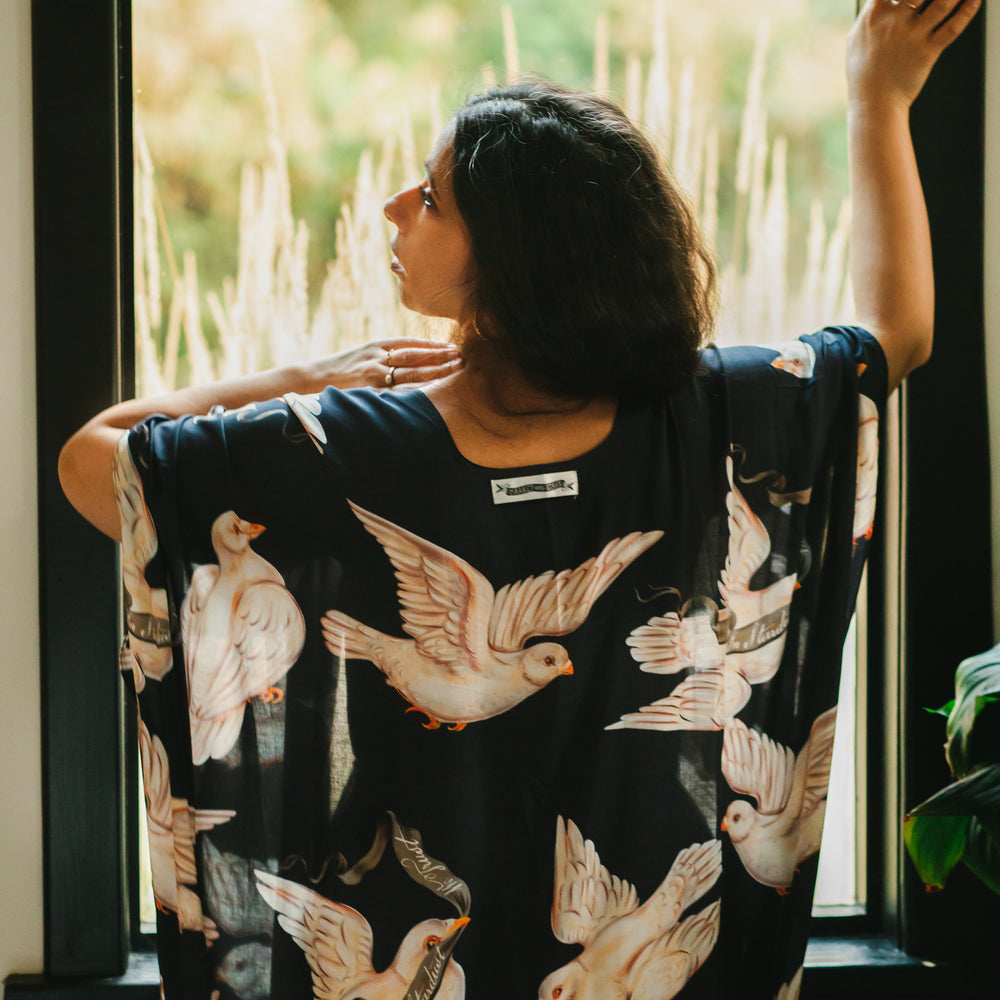 
                  
                    Model wearing the original Market of Stars kimono featuring Victorian-inspired doves and the words “In Stardust We Trust” — a tribute to dreams and possibility – Market of Stars.
                  
                