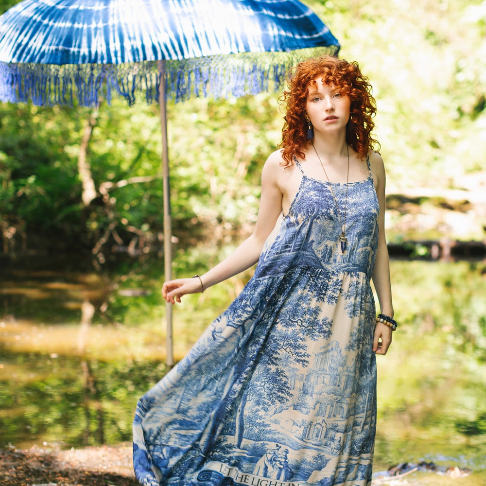 Model wearing Let the Light In bamboo viscose slip dress featuring print of Delft blue and white landscape pottery, and positive message of light and hope - Market of Stars