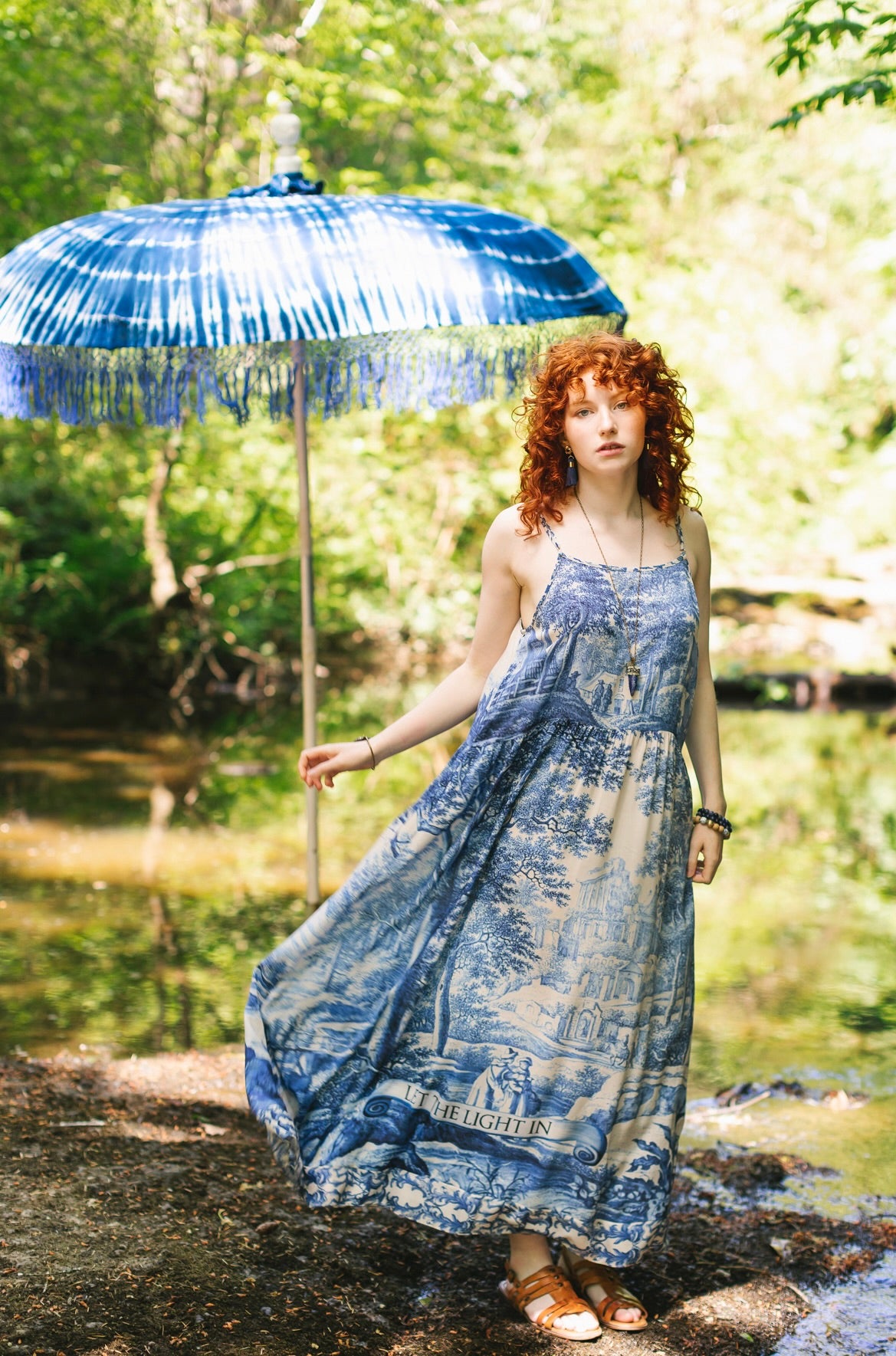 Model wearing Let the Light In bamboo viscose slip dress featuring print of Delft blue and white landscape pottery, and positive message of light and hope - Market of Stars