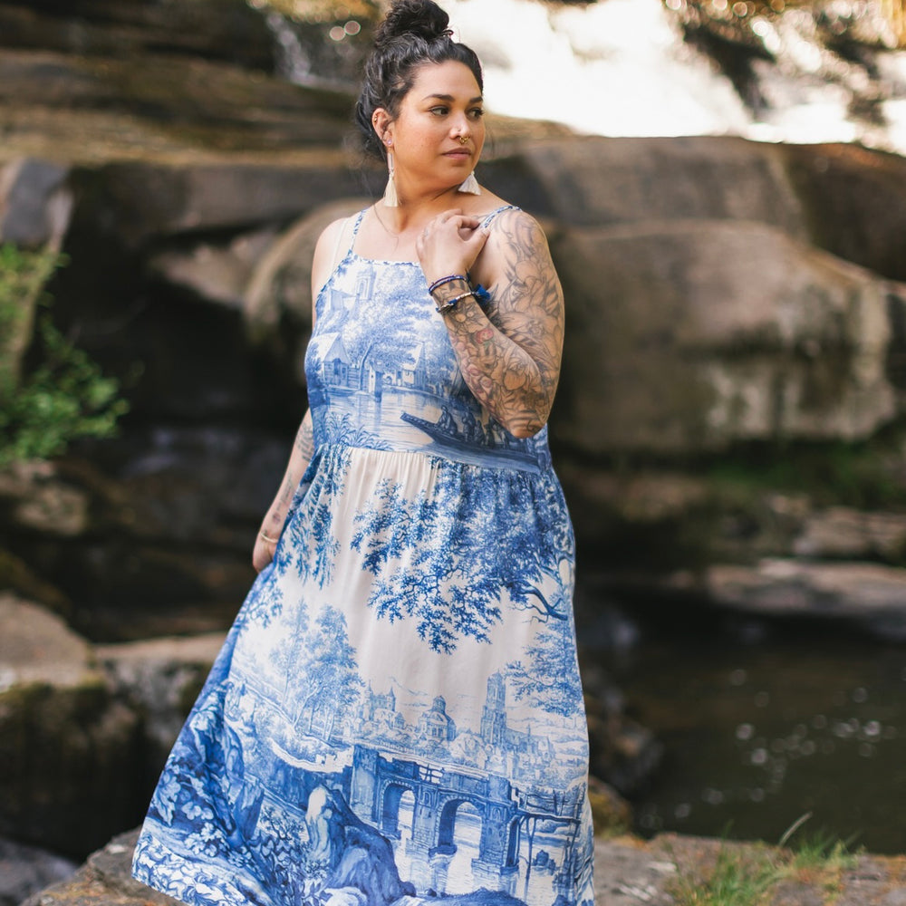 Model wearing Let the Light In bamboo viscose slip dress featuring print of Delft blue and white landscape pottery, and positive message of light and hope - Market of Stars