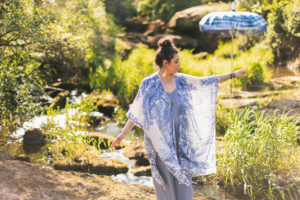 
                  
                    Model wearing Let the Light In Goddess kimono duster featuring print of Delft blue and white landscape pottery, and positive message of light and hope - Market of Stars
                  
                