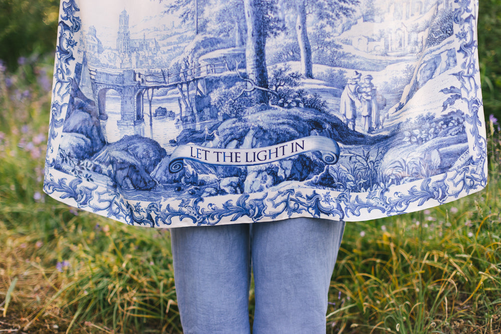 
                  
                    Model wearing Let the Light In Goddess kimono duster featuring print of Delft blue and white landscape pottery, and positive message of light and hope - Market of Stars
                  
                
