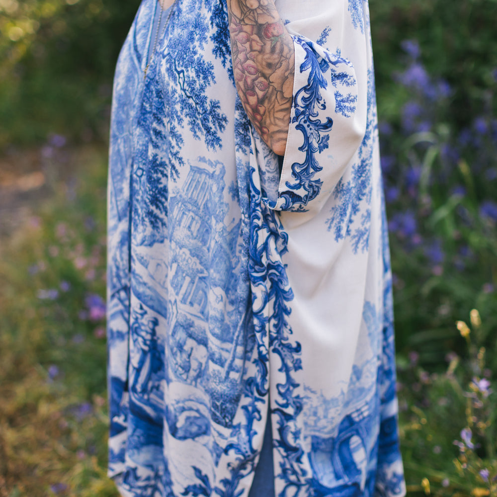 
                  
                    Model wearing Let the Light In Goddess kimono duster featuring print of Delft blue and white landscape pottery, and positive message of light and hope - Market of Stars
                  
                