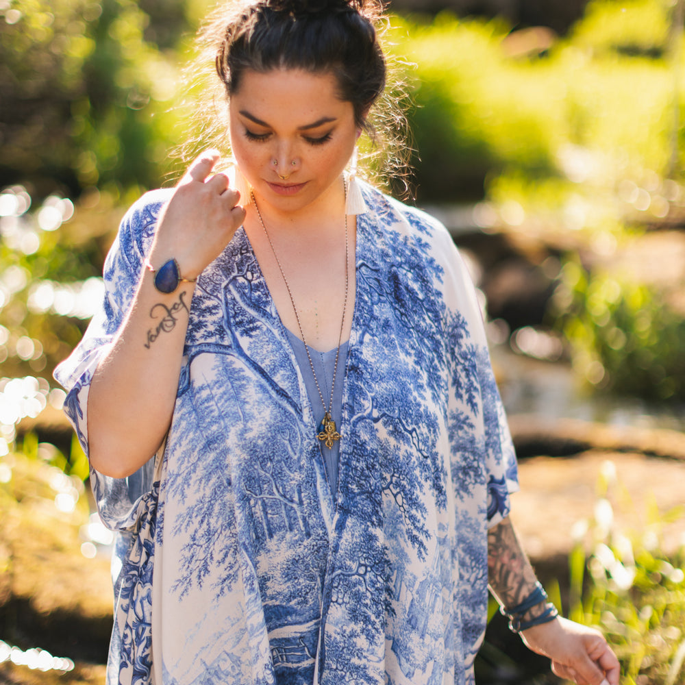 
                  
                    Model wearing Let the Light In Goddess kimono duster featuring print of Delft blue and white landscape pottery, and positive message of light and hope - Market of Stars
                  
                