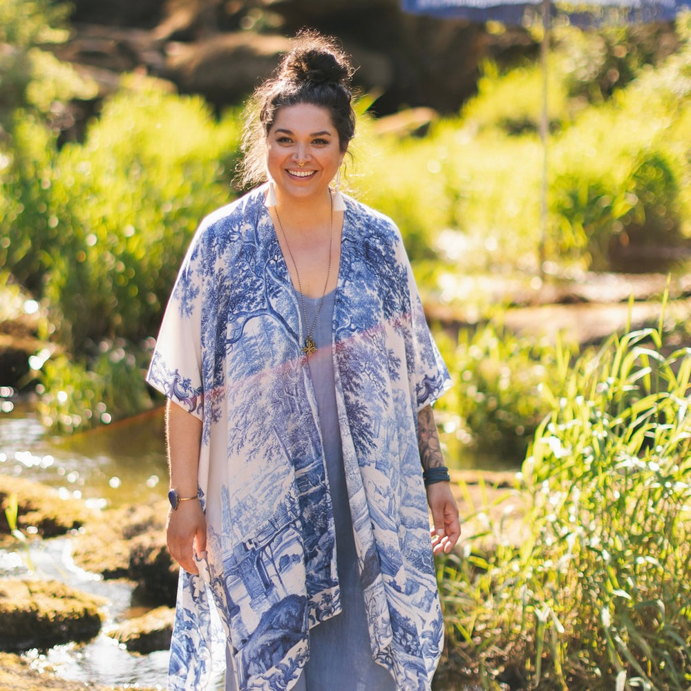 
                  
                    Model wearing Let the Light In Goddess kimono duster featuring print of Delft blue and white landscape pottery, and positive message of light and hope - Market of Stars
                  
                