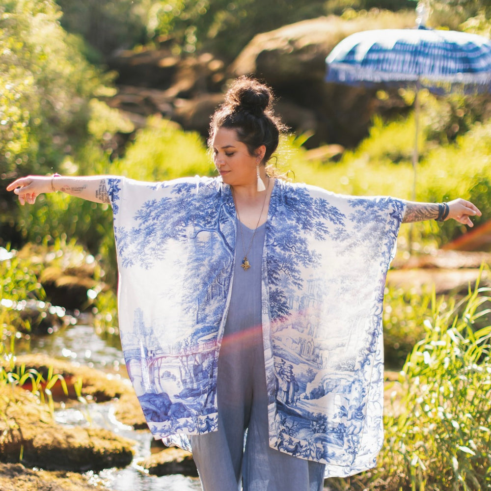 
                  
                    Model wearing Let the Light In Goddess kimono duster featuring print of Delft blue and white landscape pottery, and positive message of light and hope - Market of Stars
                  
                