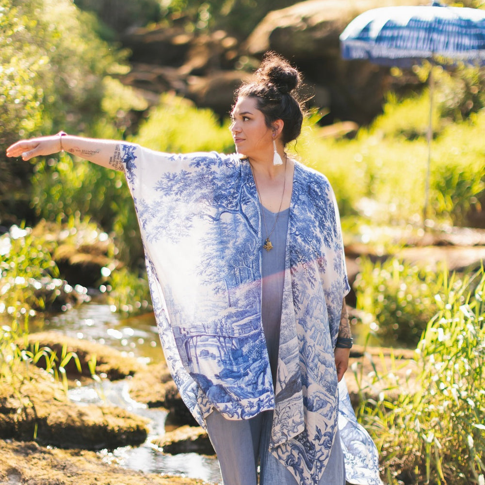 
                  
                    Model wearing Let the Light In Goddess kimono duster featuring print of Delft blue and white landscape pottery, and positive message of light and hope - Market of Stars
                  
                