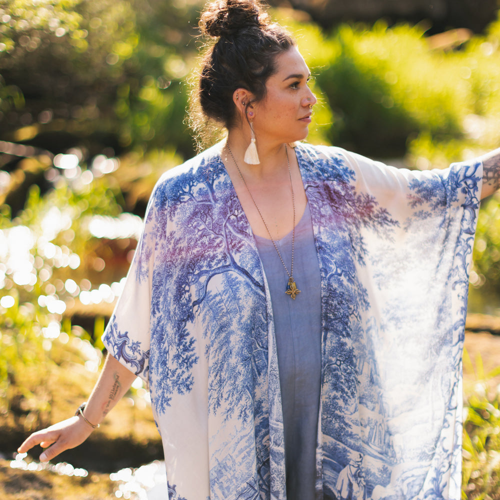 
                  
                    Model wearing Let the Light In Goddess kimono duster featuring print of Delft blue and white landscape pottery, and positive message of light and hope - Market of Stars
                  
                