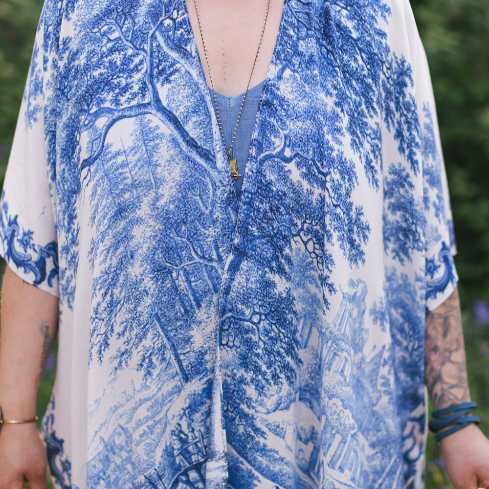 
                  
                    Model wearing Let the Light In Goddess kimono duster featuring print of Delft blue and white landscape pottery, and positive message of light and hope - Market of Stars
                  
                