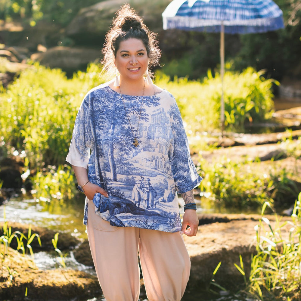 Model wearing Let the Light In bamboo viscose Luxe Tee shirt featuring print of Delft blue and white landscape pottery, and positive message of light and hope - Market of Stars