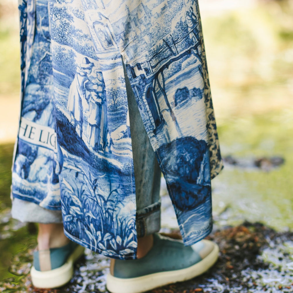 
                  
                    Model wearing Let the Light In long opera duster kimono featuring print of Delft blue and white landscape pottery, and positive message of light and hope - Market of Stars
                  
                