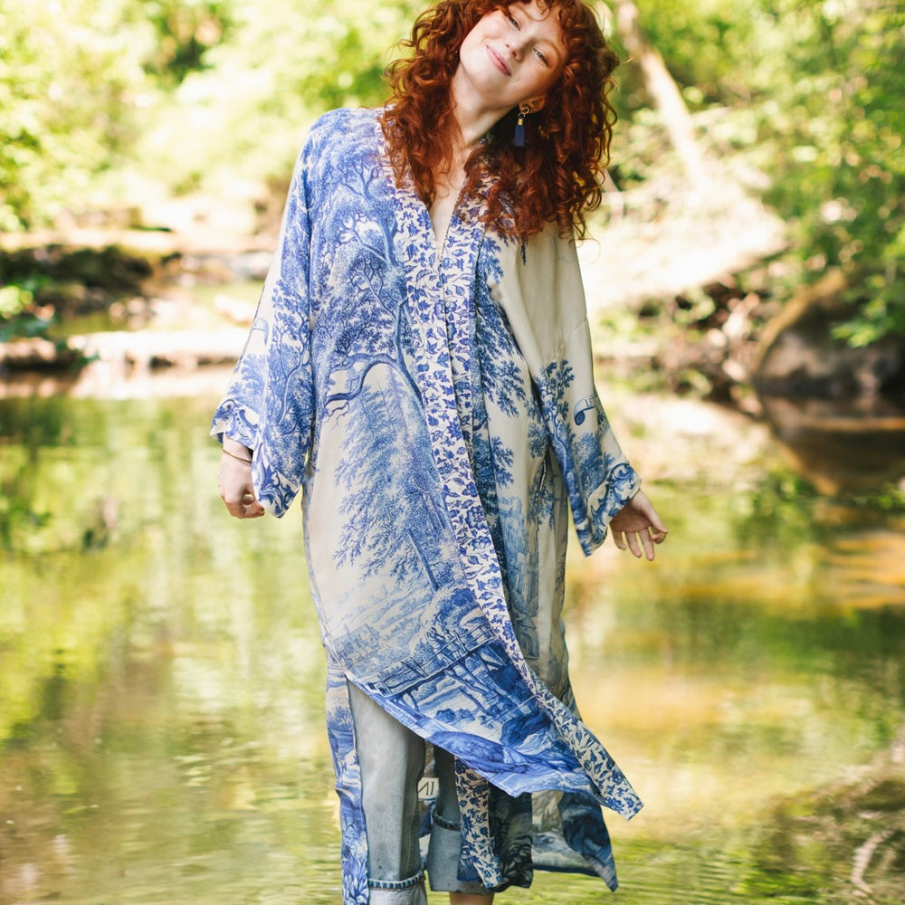 
                  
                    Model wearing Let the Light In long opera duster kimono featuring print of Delft blue and white landscape pottery, and positive message of light and hope - Market of Stars
                  
                