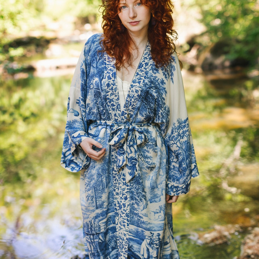 
                  
                    Model wearing Let the Light In long opera duster kimono featuring print of Delft blue and white landscape pottery, and positive message of light and hope - Market of Stars
                  
                