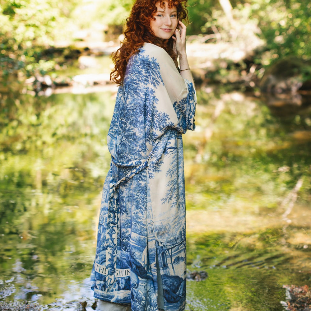 
                  
                    Model wearing Let the Light In long opera duster kimono featuring print of Delft blue and white landscape pottery, and positive message of light and hope - Market of Stars
                  
                