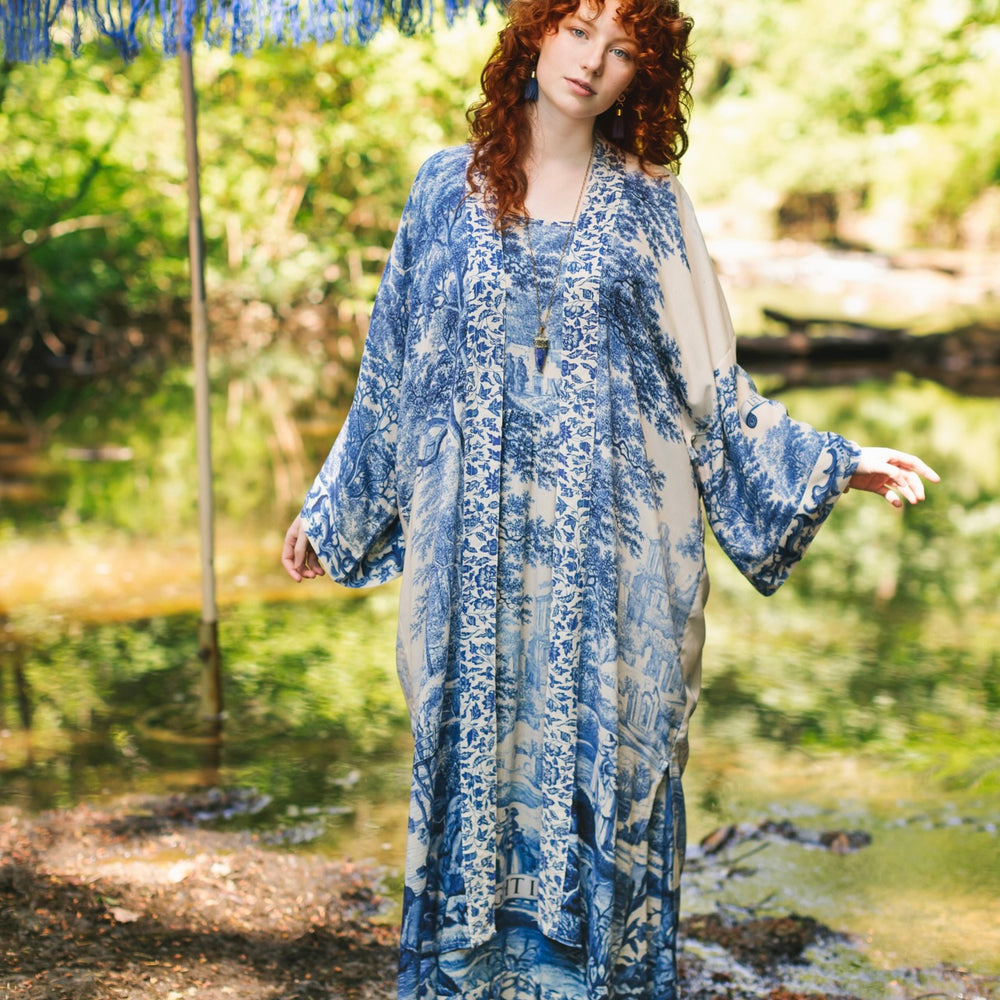 
                  
                    Model wearing Let the Light In long opera duster kimono featuring print of Delft blue and white landscape pottery, and positive message of light and hope - Market of Stars
                  
                