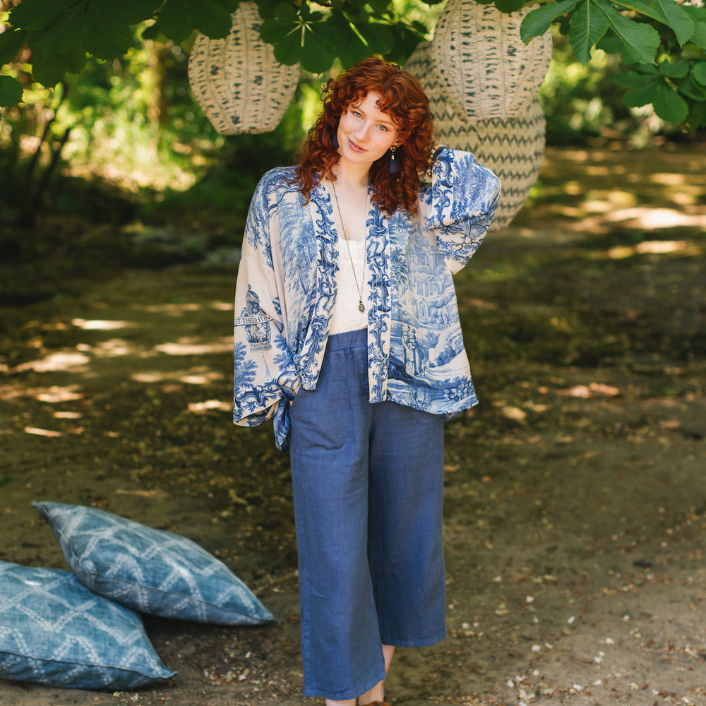 
                  
                    Model wearing Let the Light In cropped Pixie duster featuring print of Delft blue and white landscape pottery, and positive message of light and hope - Market of Stars
                  
                