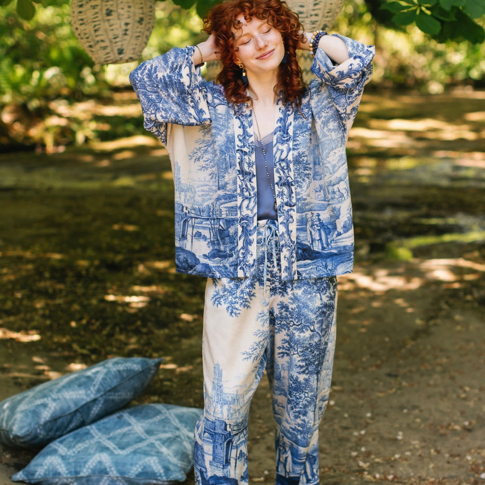 
                  
                    Model wearing Let the Light In cropped Pixie duster featuring print of Delft blue and white landscape pottery, and positive message of light and hope - Market of Stars
                  
                