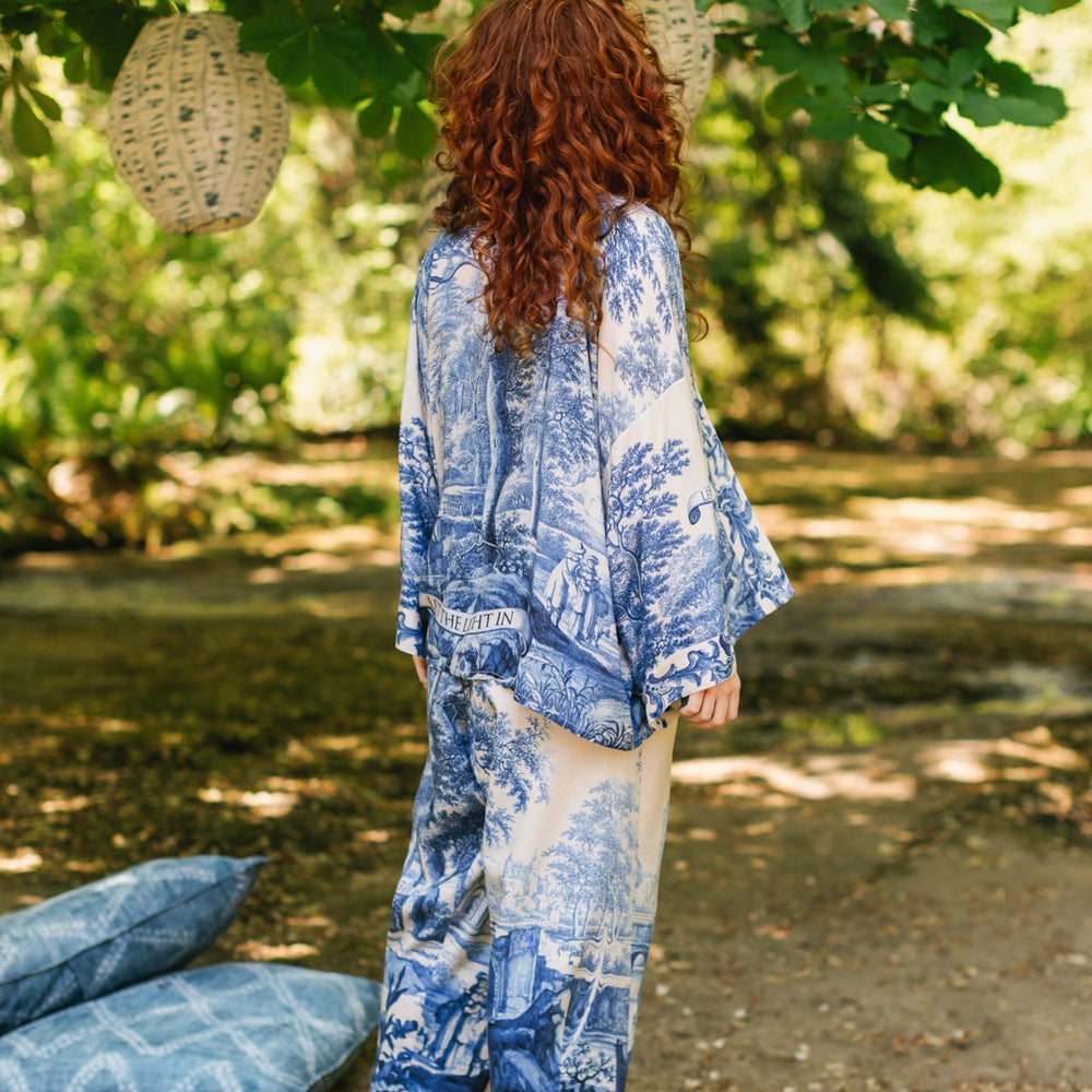 
                  
                    Model wearing Let the Light In cropped Pixie duster featuring print of Delft blue and white landscape pottery, and positive message of light and hope - Market of Stars
                  
                