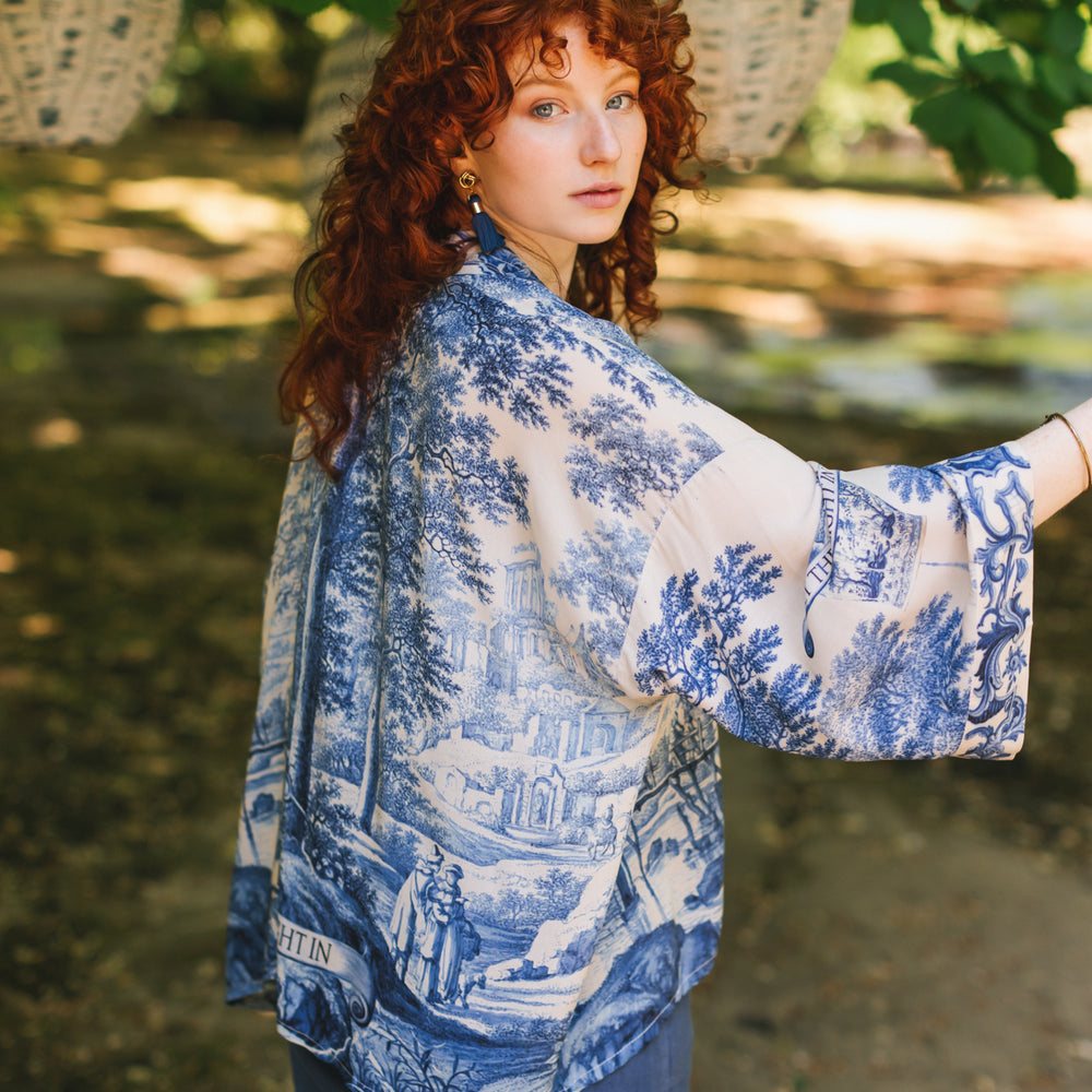 
                  
                    Model wearing Let the Light In cropped Pixie duster featuring print of Delft blue and white landscape pottery, and positive message of light and hope - Market of Stars
                  
                