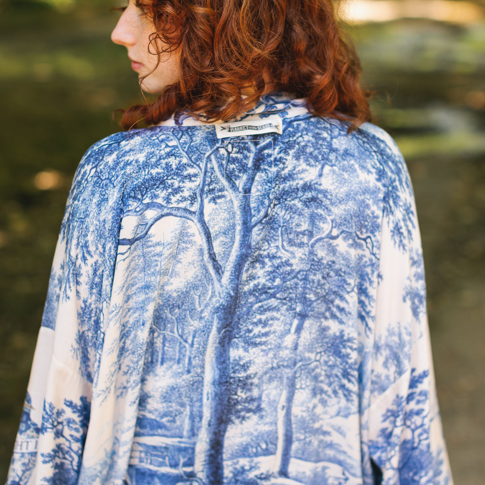 
                  
                    Model wearing Let the Light In cropped Pixie duster featuring print of Delft blue and white landscape pottery, and positive message of light and hope - Market of Stars
                  
                
