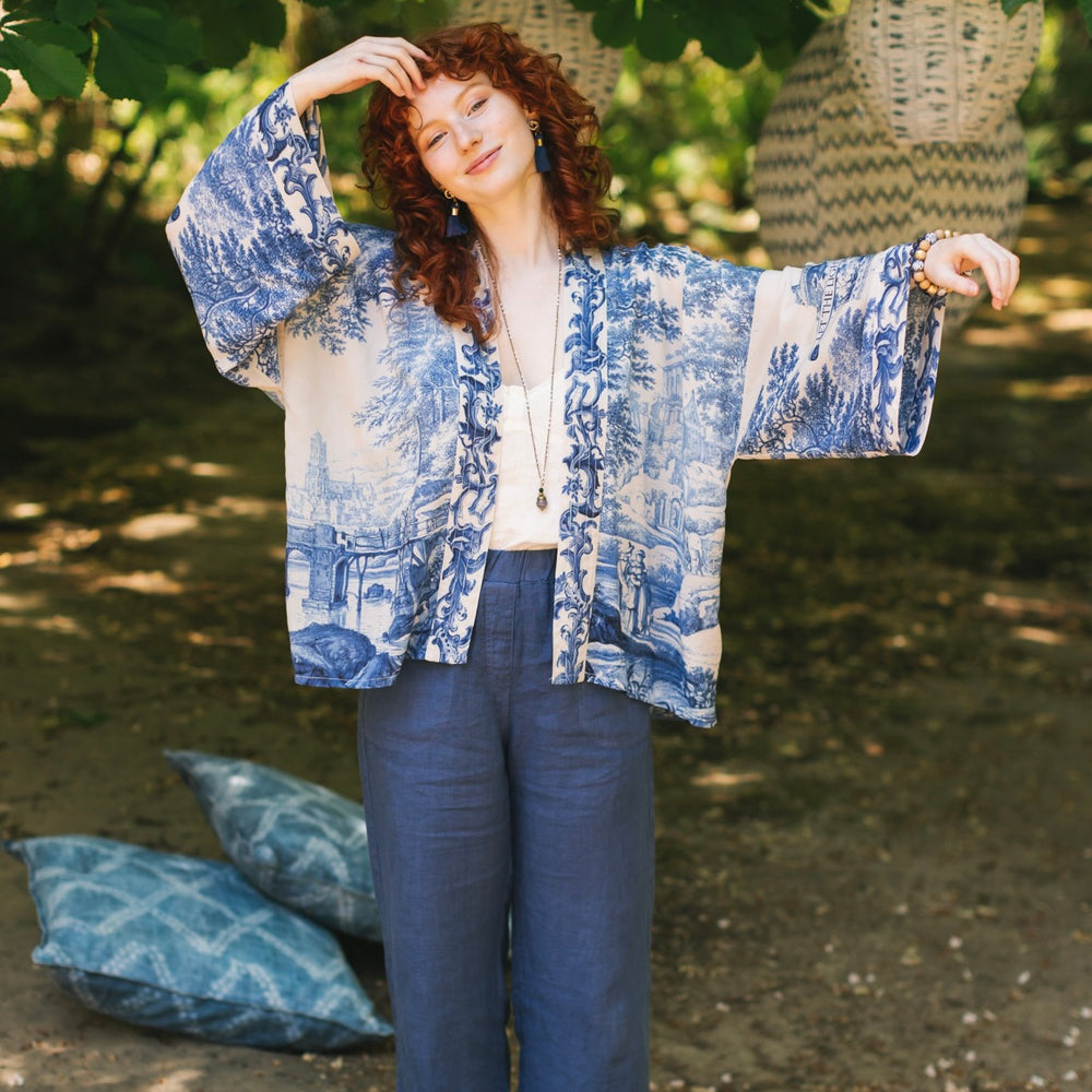 
                  
                    Model wearing Let the Light In cropped Pixie duster featuring print of Delft blue and white landscape pottery, and positive message of light and hope - Market of Stars
                  
                