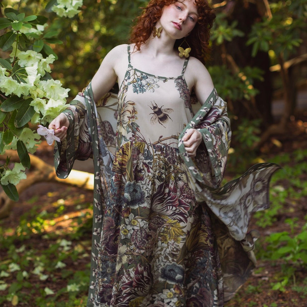 Model wearing Love Grows Wild Bohéme Slip Dress featuring hand-coloured 1700s botanical etchings and bumblebee detail – adjustable, flowy, and reversible – Market of Stars.