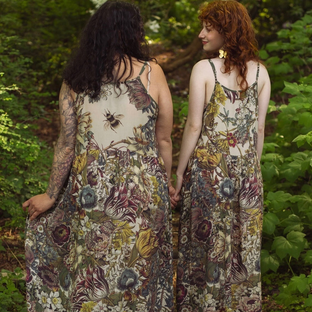 
                  
                    Model wearing Love Grows Wild Bohéme Slip Dress featuring hand-coloured 1700s botanical etchings and bumblebee detail – adjustable, flowy, and reversible – Market of Stars.
                  
                