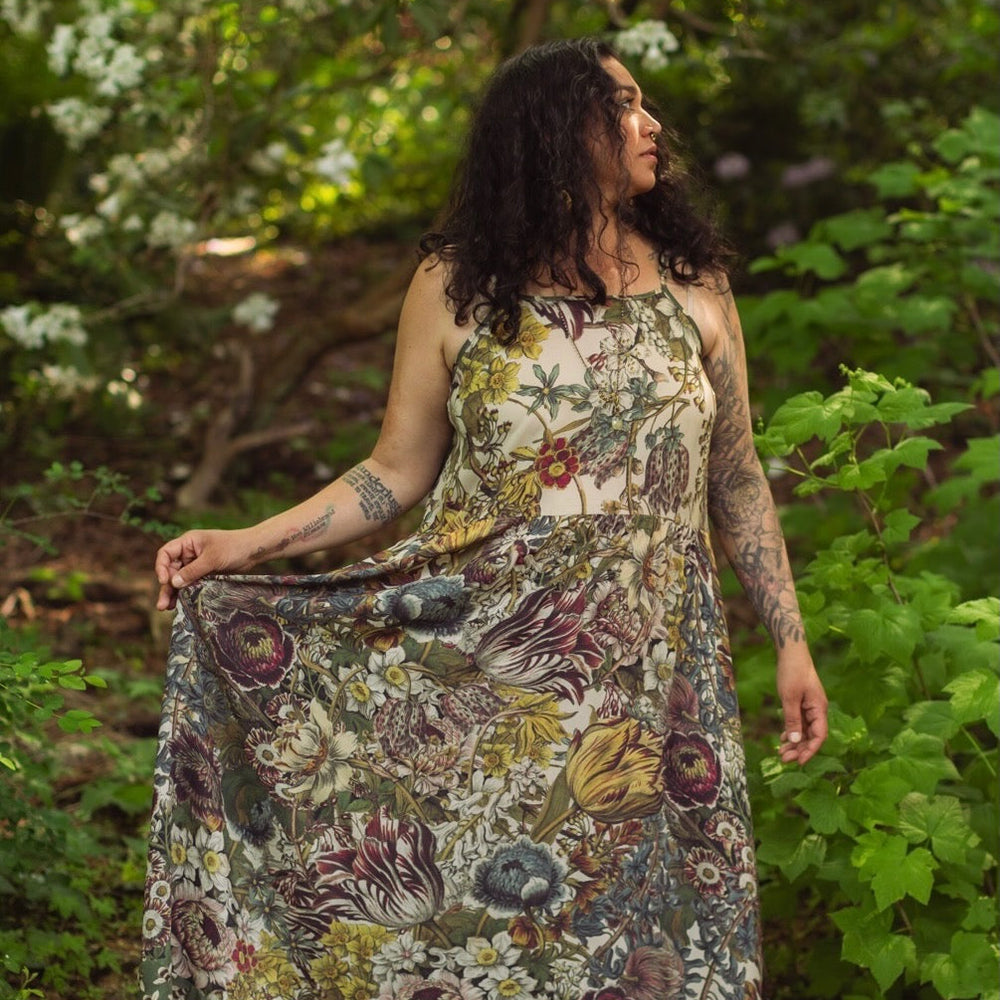 
                  
                    Model wearing Love Grows Wild Bohéme Slip Dress featuring hand-coloured 1700s botanical etchings and bumblebee detail – adjustable, flowy, and reversible – Market of Stars.
                  
                