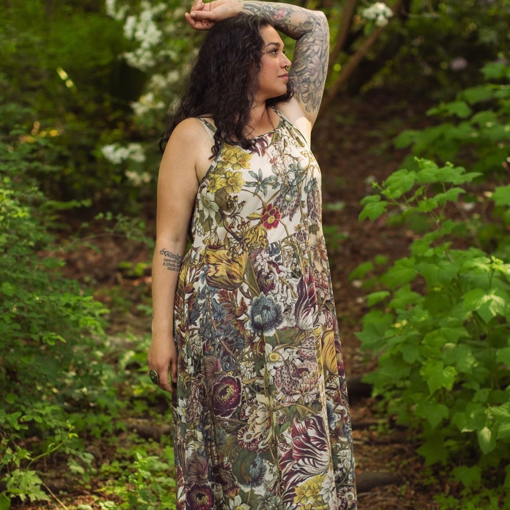
                  
                    Model wearing Love Grows Wild Bohéme Slip Dress featuring hand-coloured 1700s botanical etchings and bumblebee detail – adjustable, flowy, and reversible – Market of Stars.
                  
                