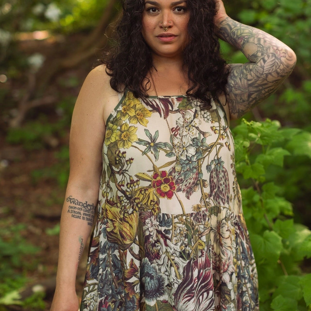 
                  
                    Model wearing Love Grows Wild Bohéme Slip Dress featuring hand-coloured 1700s botanical etchings and bumblebee detail – adjustable, flowy, and reversible – Market of Stars.
                  
                