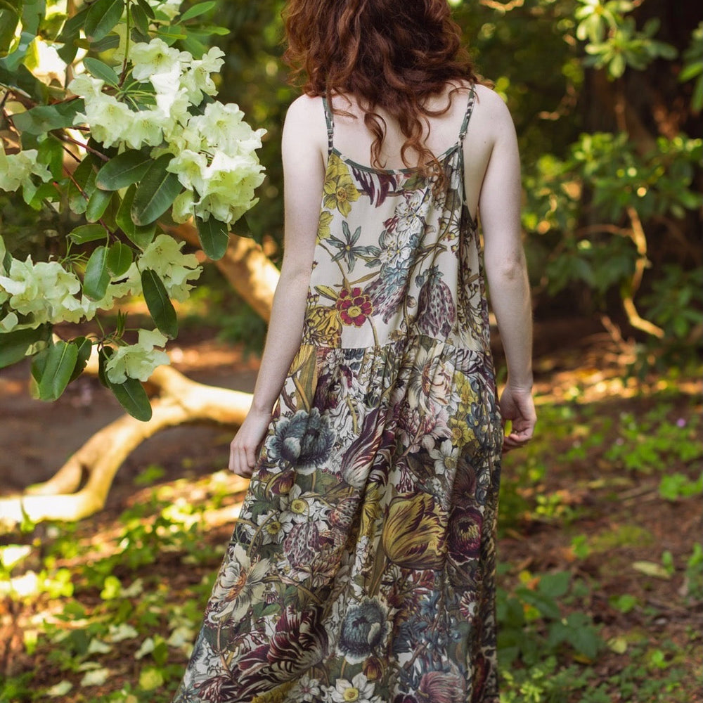 
                  
                    Model wearing Love Grows Wild Bohéme Slip Dress featuring hand-coloured 1700s botanical etchings and bumblebee detail – adjustable, flowy, and reversible – Market of Stars.
                  
                