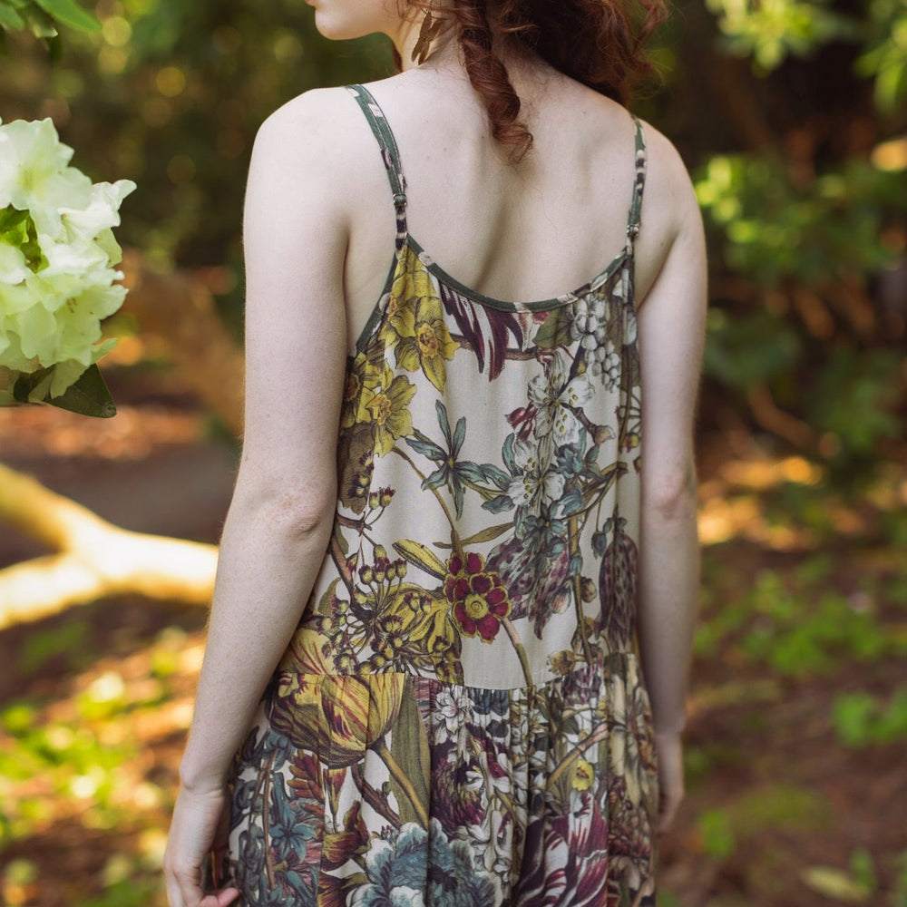 
                  
                    Model wearing Love Grows Wild Bohéme Slip Dress featuring hand-coloured 1700s botanical etchings and bumblebee detail – adjustable, flowy, and reversible – Market of Stars.
                  
                