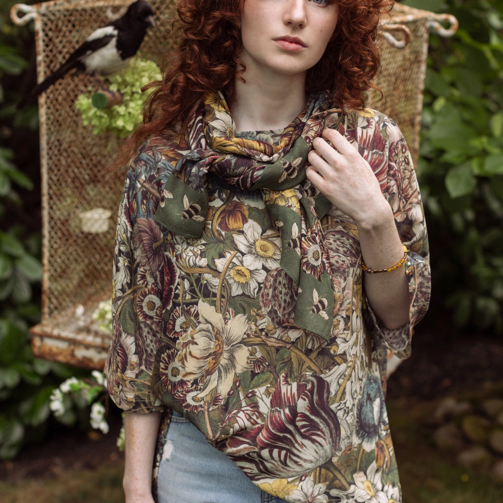 
                  
                    Model wearing the Love Grows Wild Luxe Tee featuring lush floral etchings inspired by 1700s botanical art with hidden bee trim detail – Market of Stars.
                  
                