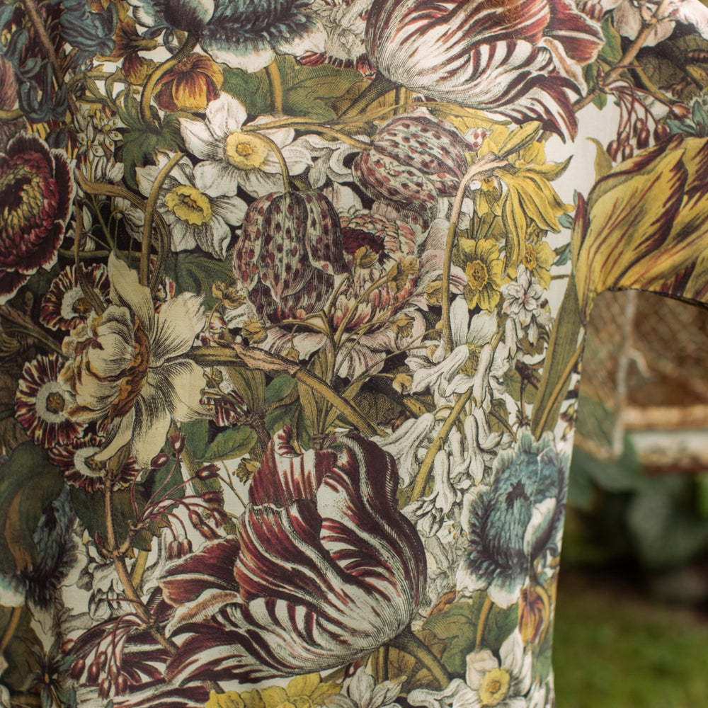 
                  
                    Model wearing the Love Grows Wild Luxe Tee featuring lush floral etchings inspired by 1700s botanical art with hidden bee trim detail – Market of Stars.
                  
                