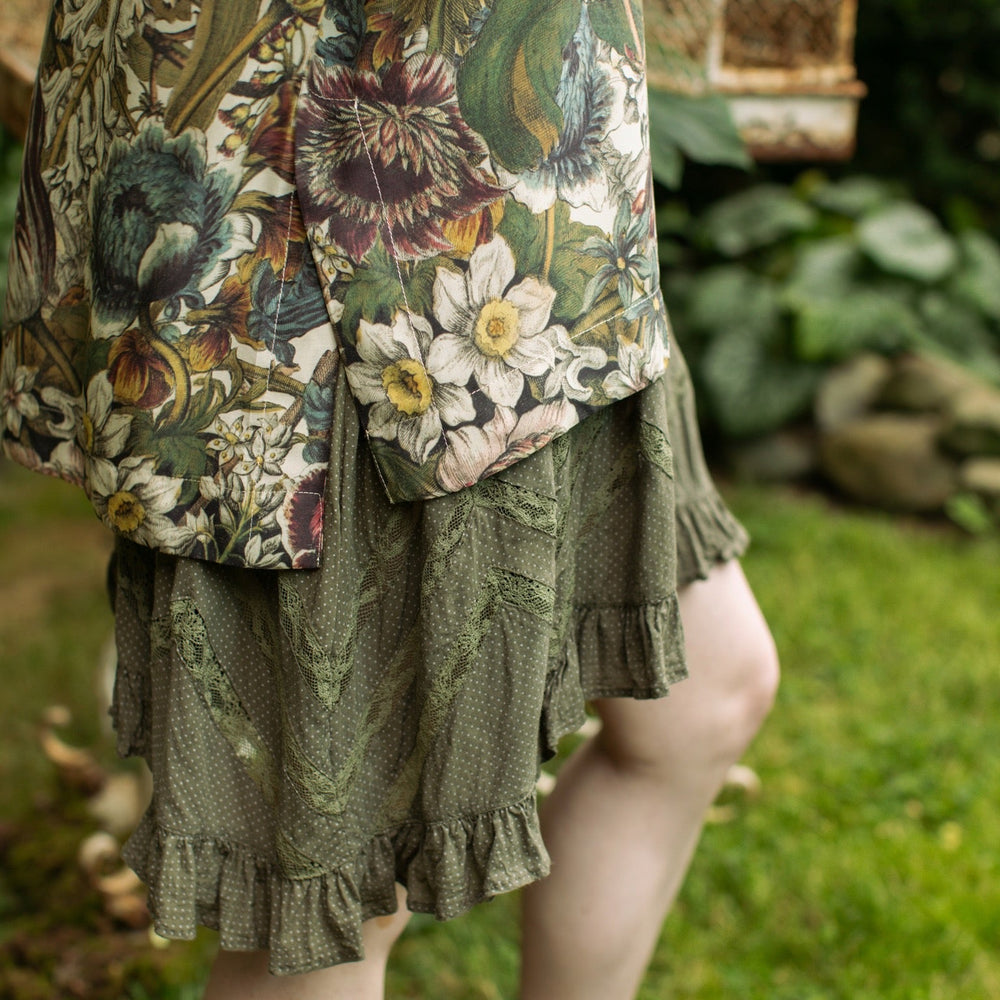 
                  
                    Model wearing the Love Grows Wild Luxe Tee featuring lush floral etchings inspired by 1700s botanical art with hidden bee trim detail – Market of Stars.
                  
                